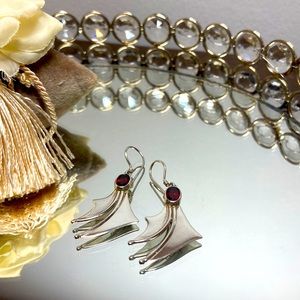 Silver earrings with red gemstones.